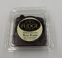 Box of Chocolate Rum Raisin fudge with a clear lid on a light gray background