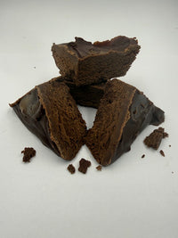Broken pieces of dark chocolate on a white background