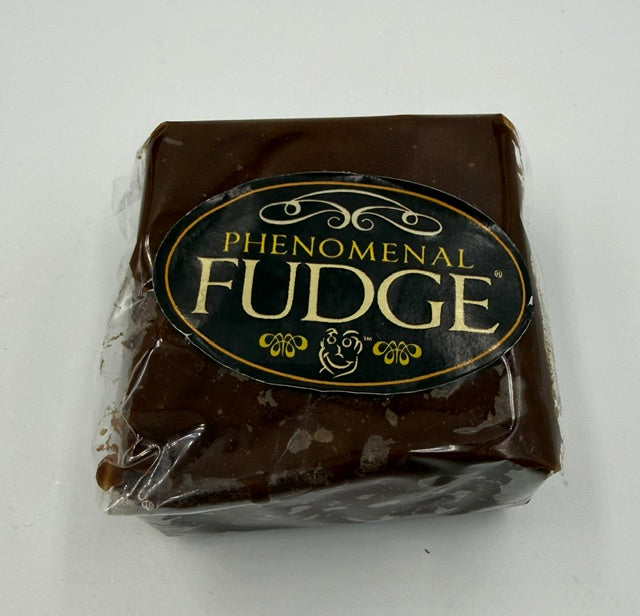 A square package of Phenomenal Fudge wrapped in clear plastic with a black and gold oval label, shown on a plain white background.